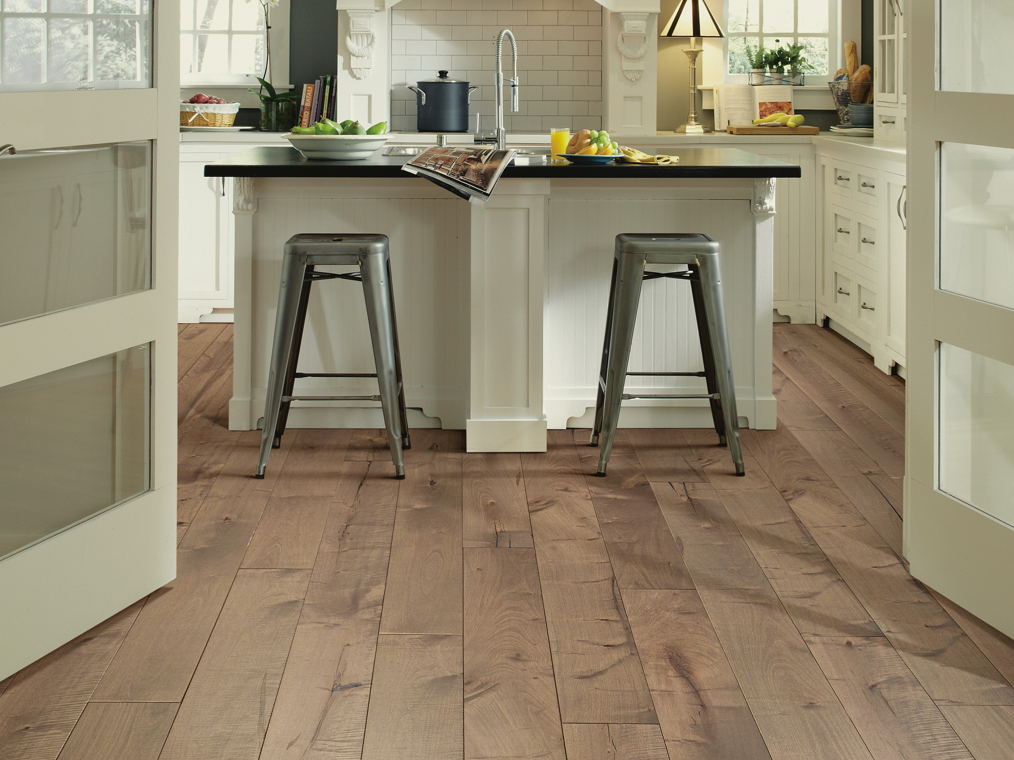 Modern kitchen with light brown hardwood flooring and white cabinetry